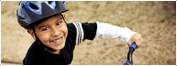 Close up of a child smiling and riding a bike